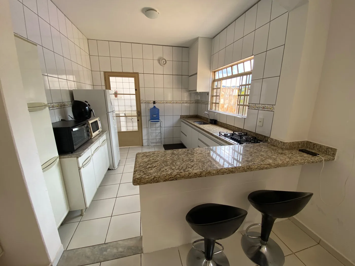 Cozinha equipada com fogão, geladeira e bancada